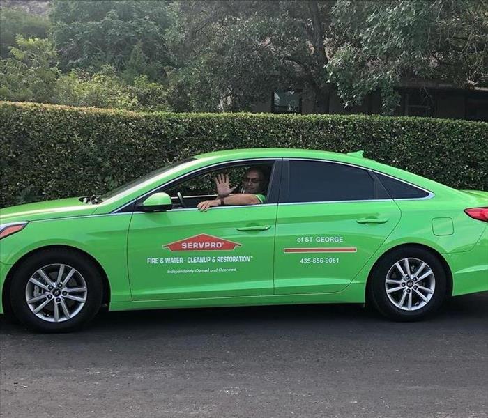 a man in a green SERVPRO car